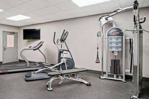 Un gimnasio con cintas de correr, elípticas y máquinas de pesas.