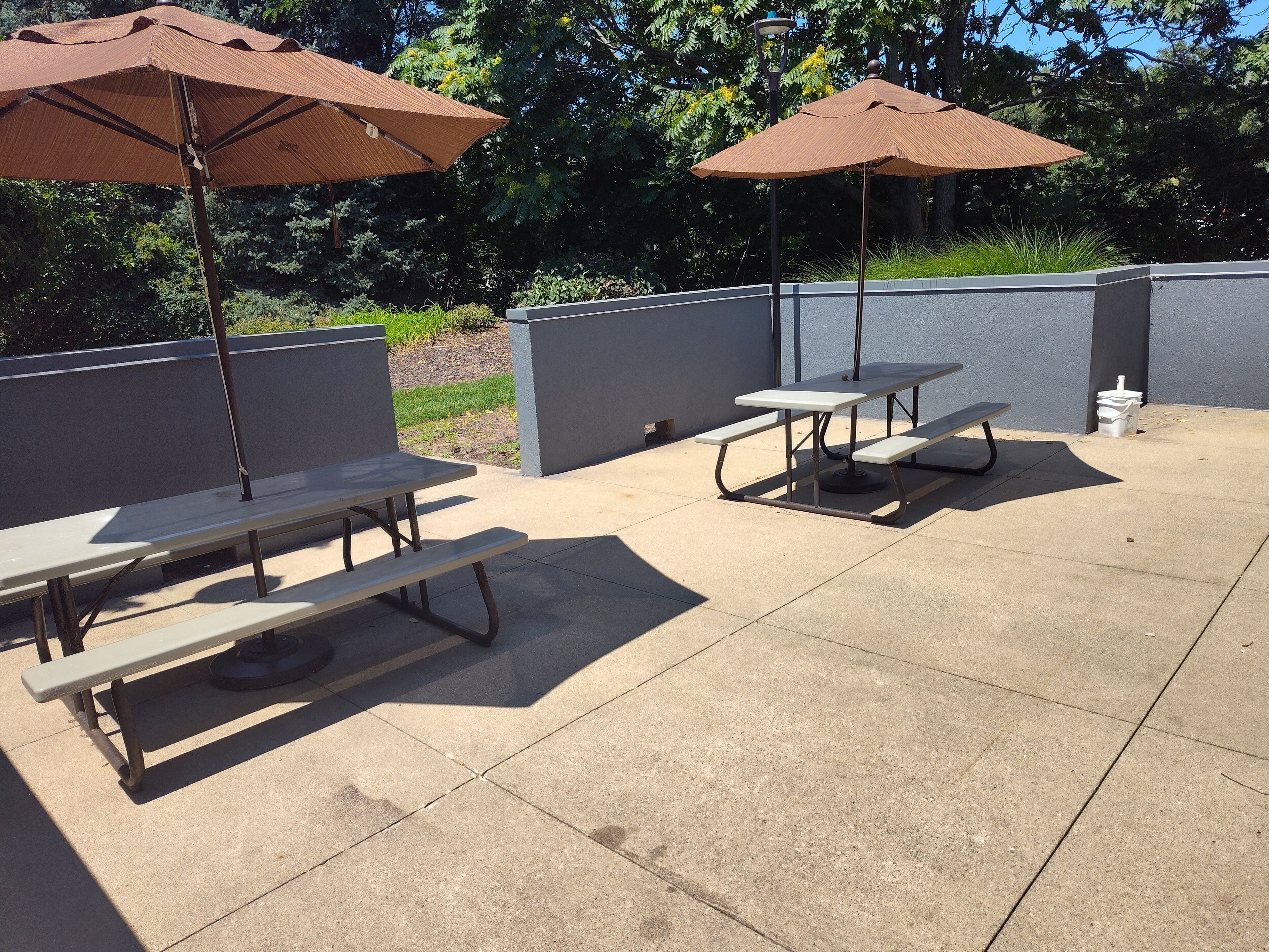 An outdoor patio area with picnic tables and umbrellas.