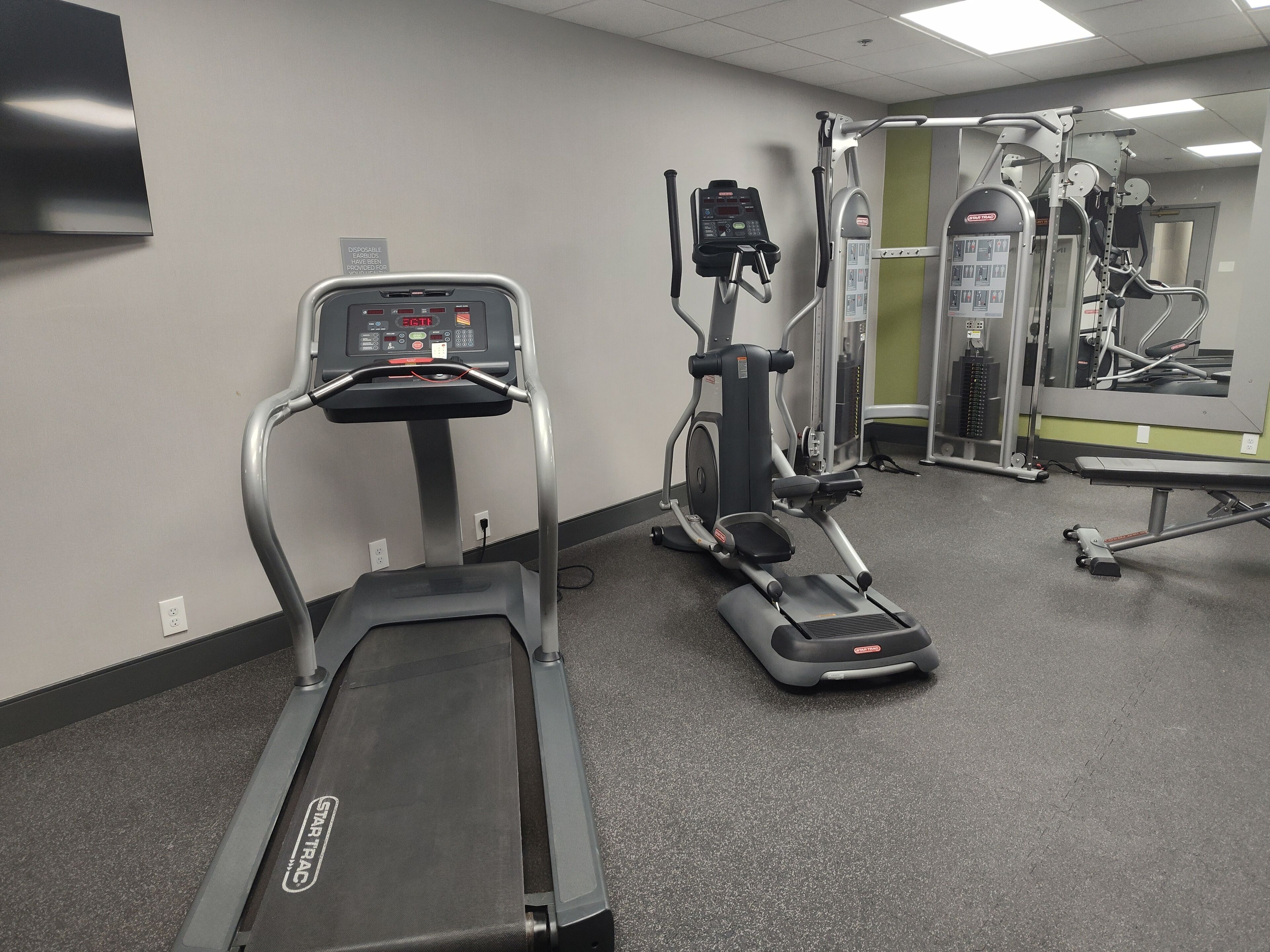 A gym with treadmills, elliptical machines, and weight equipment.