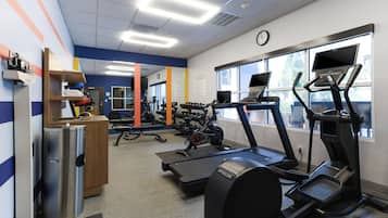 Un gimnasio con cintas de correr, elípticas y máquinas de pesas.