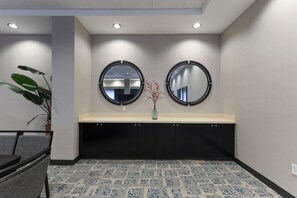Un baño de hotel con dos espejos redondos, un lavabo y un piso con diseño.