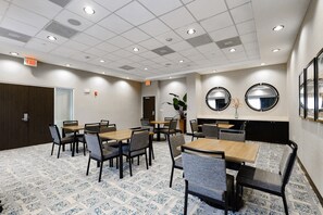 A hotel room with a tiled ceiling, multiple tables and chairs, a door, and a wall-mounted mirror. - Hampton Inn Miami-Coconut Grove/Coral Gables (Miami)