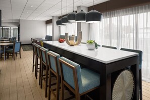 Un comedor moderno con una mesa larga, varias sillas e iluminación colgante.