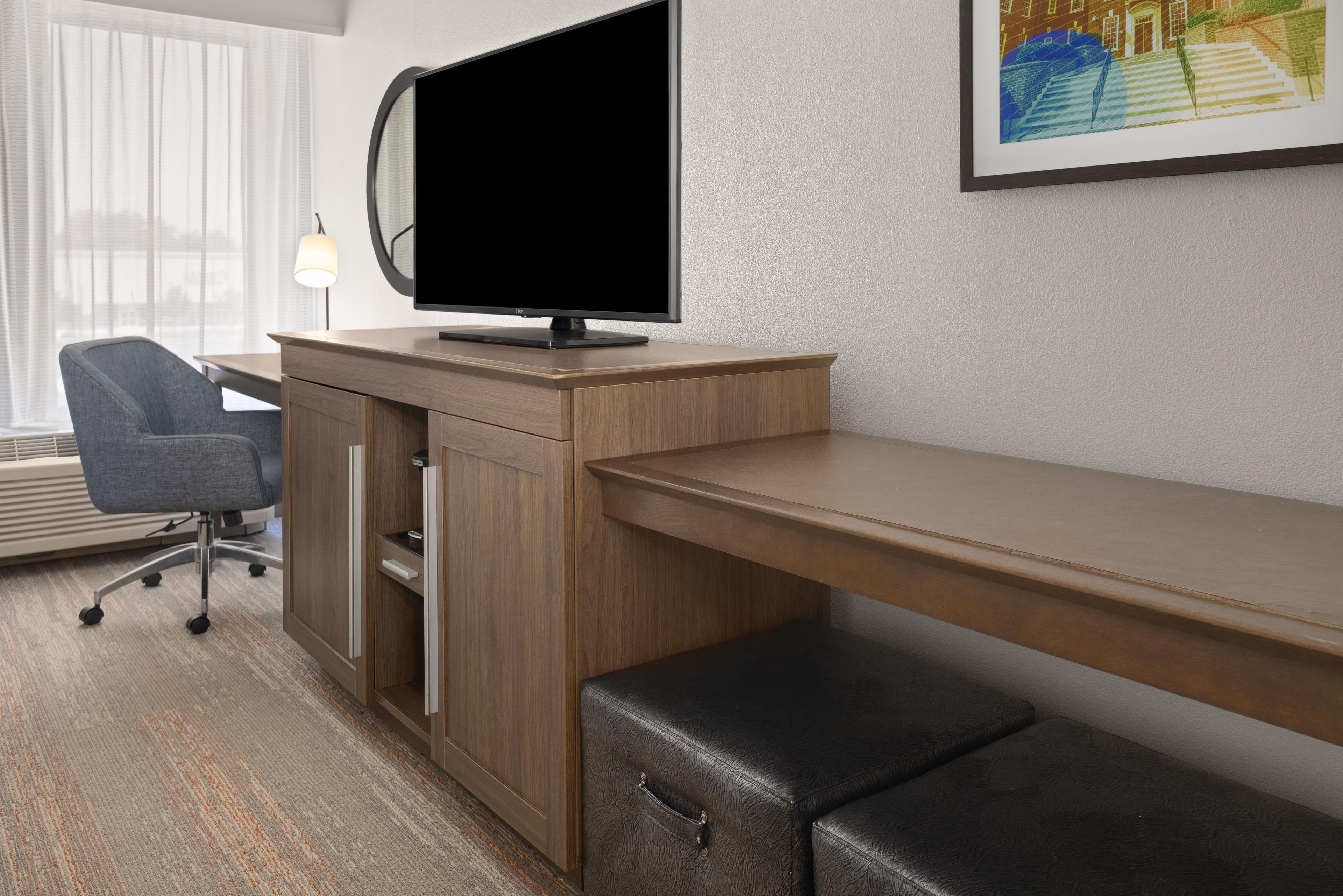 Un espacio de oficina moderno con un escritorio, una silla y un monitor de pantalla plana.