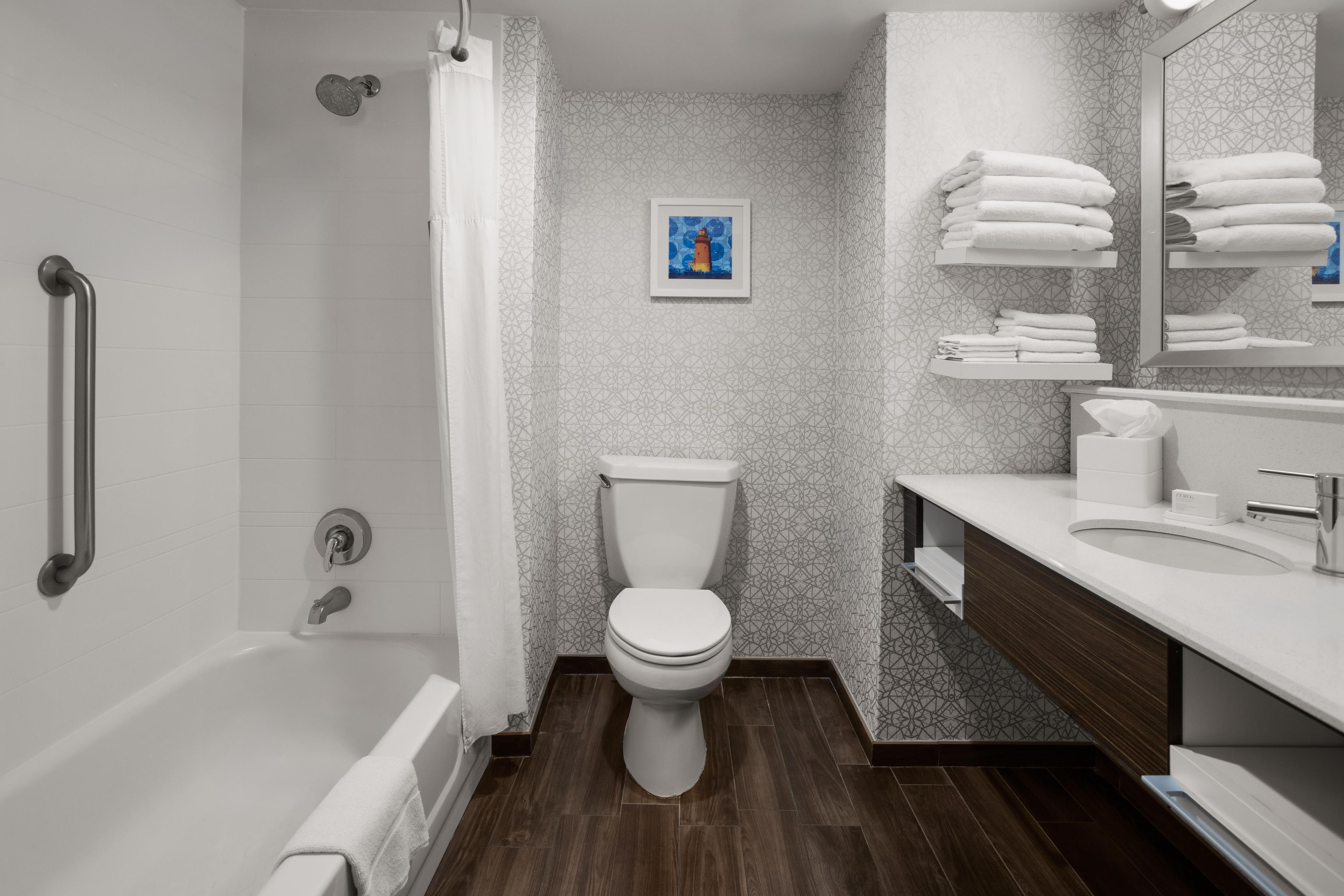 Une salle de bain moderne équipée d’une douche, de toilettes et d’un meuble-lavabo.