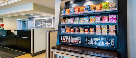 A snack display with various brands and a refrigerated section with beverages.