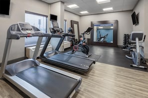 A gym with treadmills, an exercise bike, and a mirrored wall. - Hampton Inn Dover (Dover)