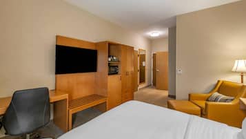 Ein Hotelzimmer mit Bett, Schreibtisch, Stuhl, Kleiderschrank und Fernseher.
