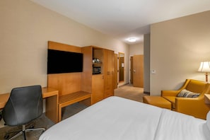 A hotel room with a bed, a desk, a chair, a wardrobe, and a television. - Comfort Inn Missoula North Shopping District (Missoula)