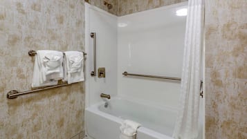 Un baño con bañera, ducha y barandilla.