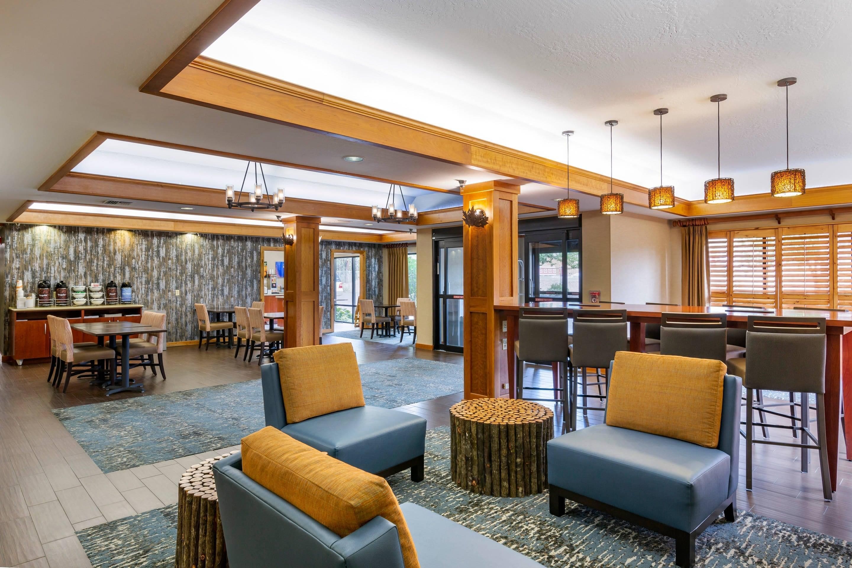 Un vestíbulo de hotel con zonas de estar, un bar y un comedor.