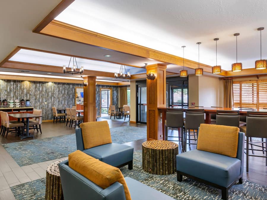A hotel lobby with seating areas, a bar, and a dining area.