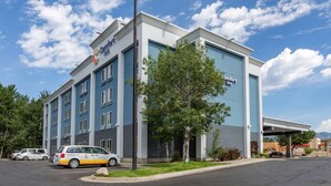 Un hôtel Comfort Inn doté d’une façade moderne, d’un mât pour drapeau et d’un parking avec un service de navette.