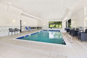 An indoor swimming pool with lounge chairs and a bar area. - Hampton Inn Washington (Washington)