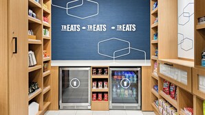 A grocery store interior with shelves stocked with various products and two refrigerated display cases. - Hampton Inn Provo (Provo)