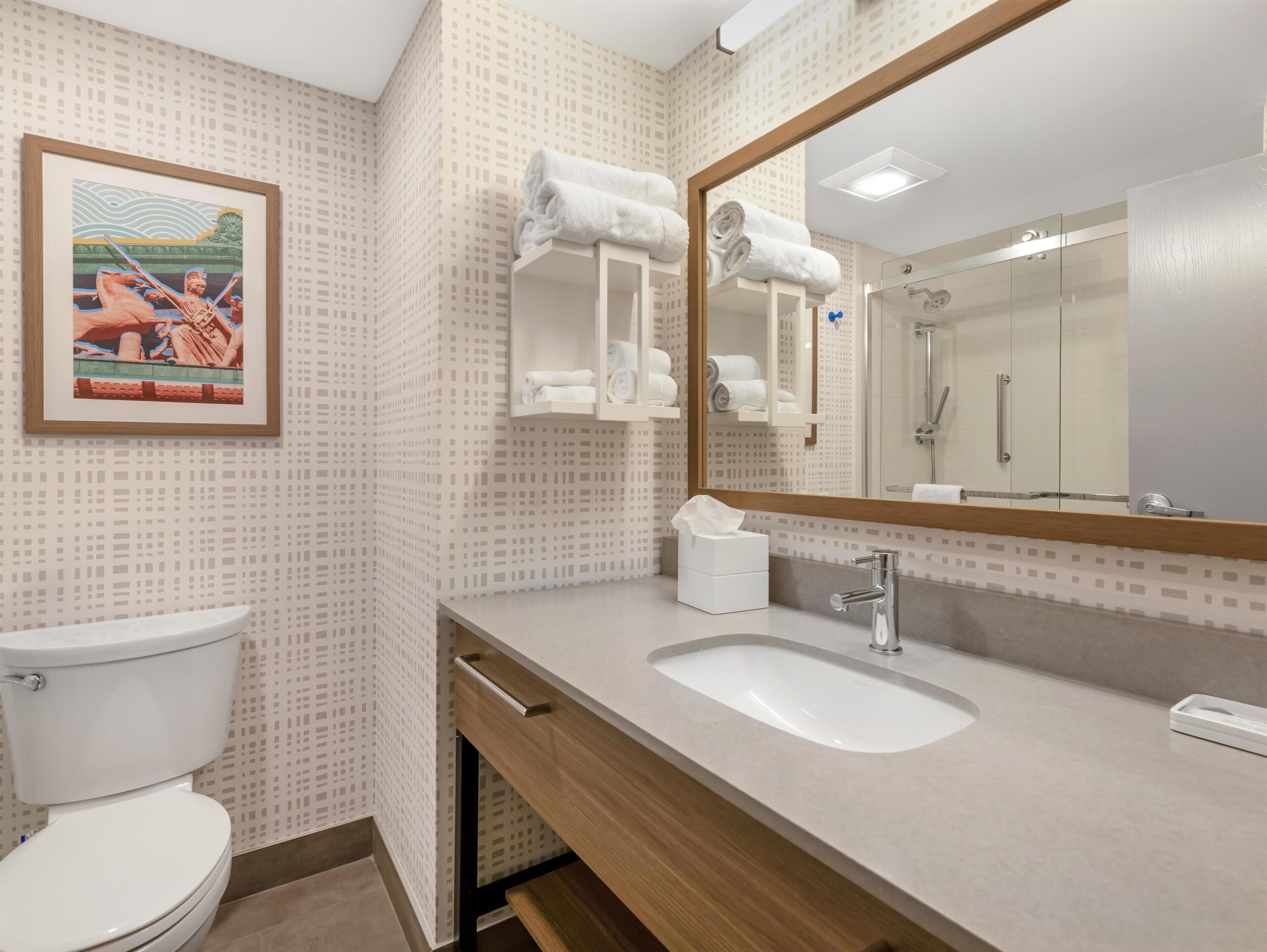 Une salle de bain moderne équipée de toilettes, d’un lavabo et d’une douche.