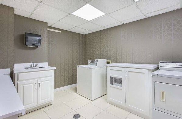 A laundry room with a washing machine, dryer, and a sink with a mirror. - Hampton Inn Cullman (Cullman)