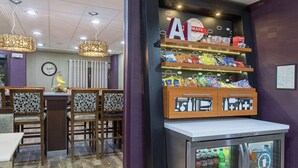 A restaurant interior with a counter, seating area, and a display of snacks and beverages. - Hampton Inn Cullman (Cullman)