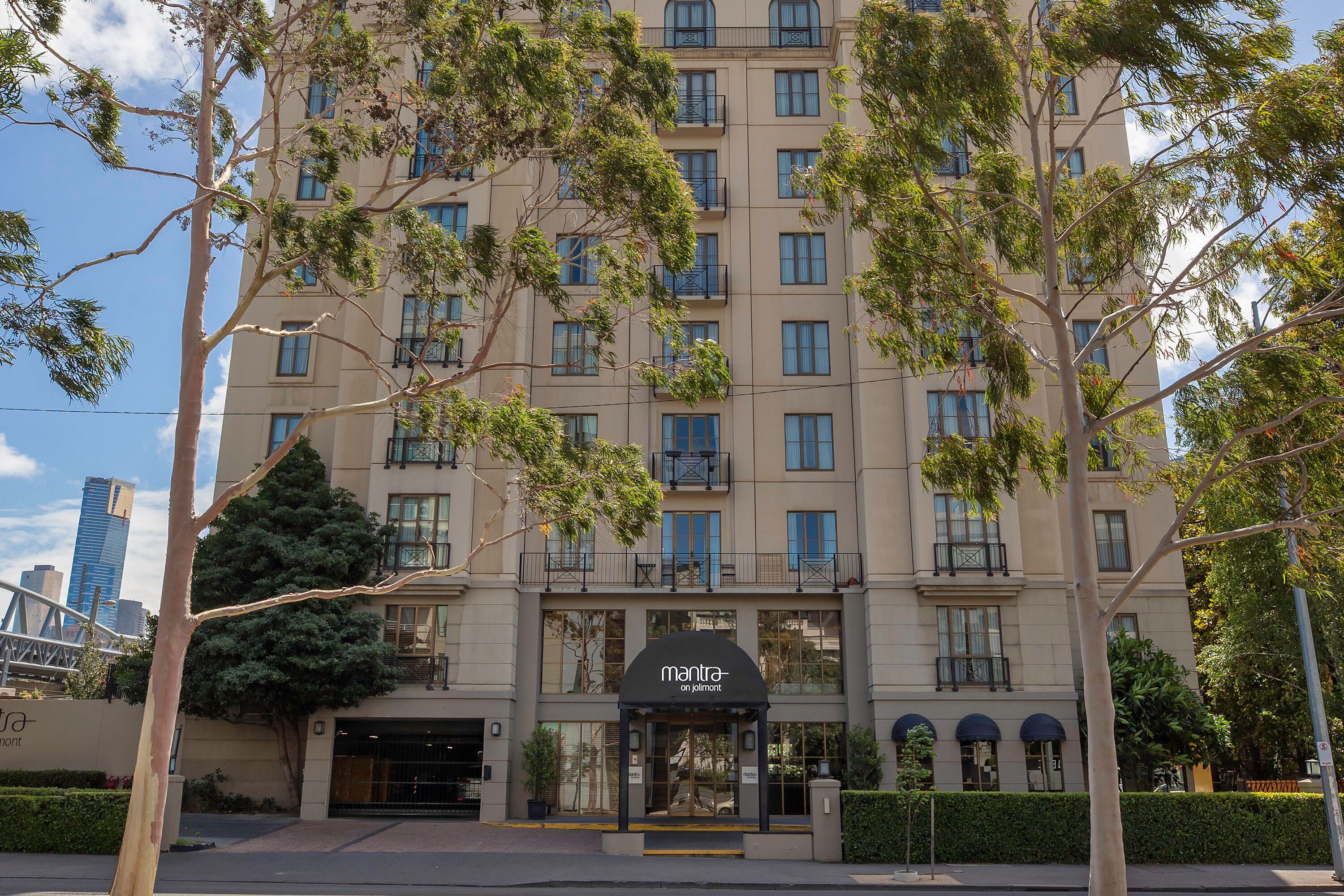 A multi-story hotel with a modern facade, large windows, and a prominent entrance with a sign.