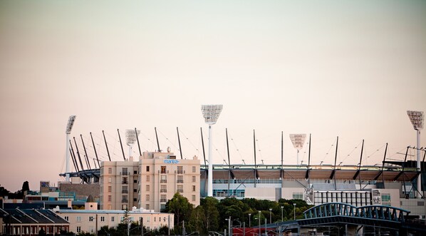 A stadium with multiple tiers of seating and tall light structures. - Mantra on Jolimont Melbourne (East Melbourne)