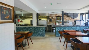 A restaurant with a kitchen area, wooden tables, and chairs. - Haven Glebe (Glebe)