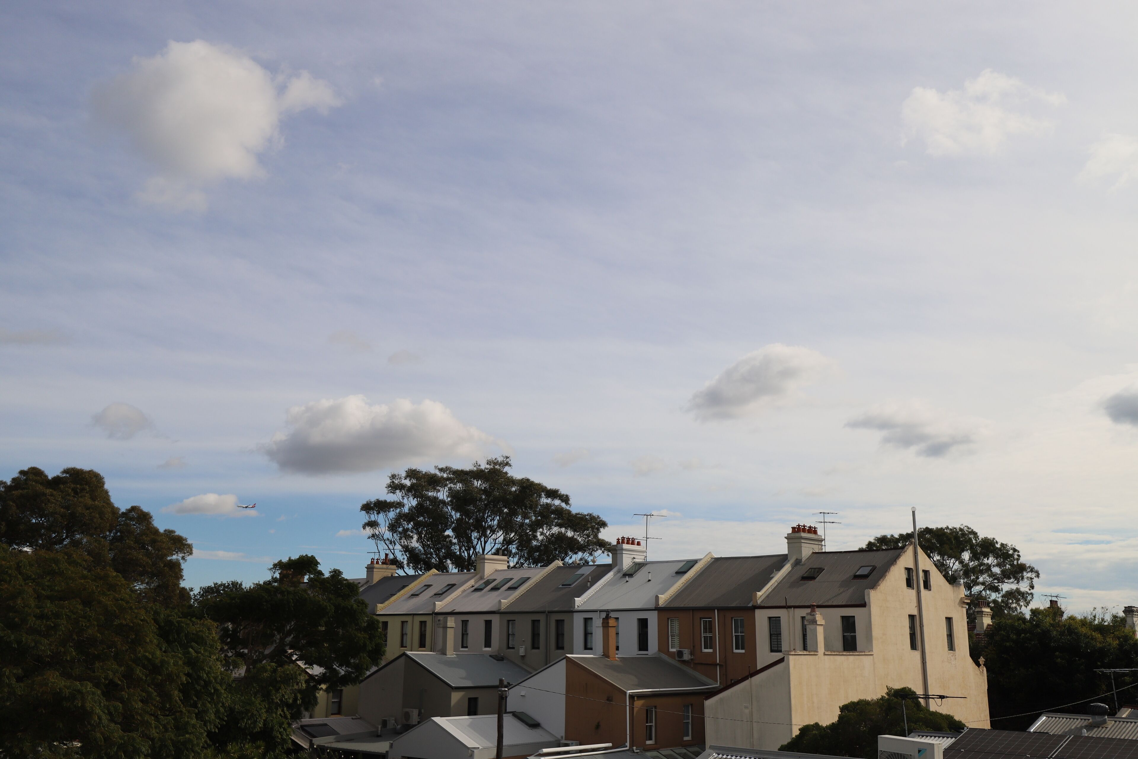 A row of terraced houses with pitched roofs and chimneys.