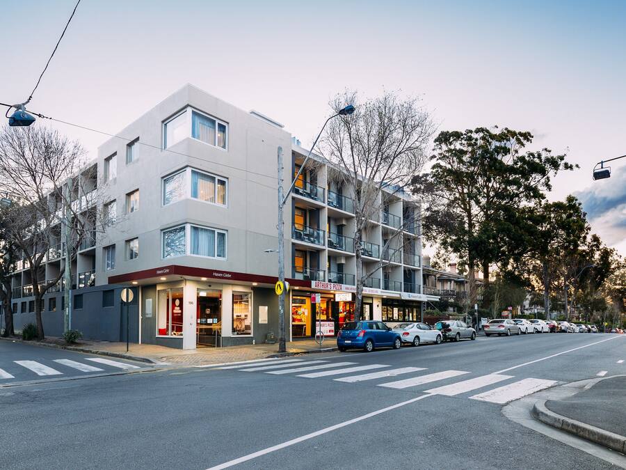 A multi-story hotel with a modern design, featuring a ground-floor restaurant and a visible entrance.