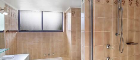 A bathroom with a bathtub, toilet, and shower.