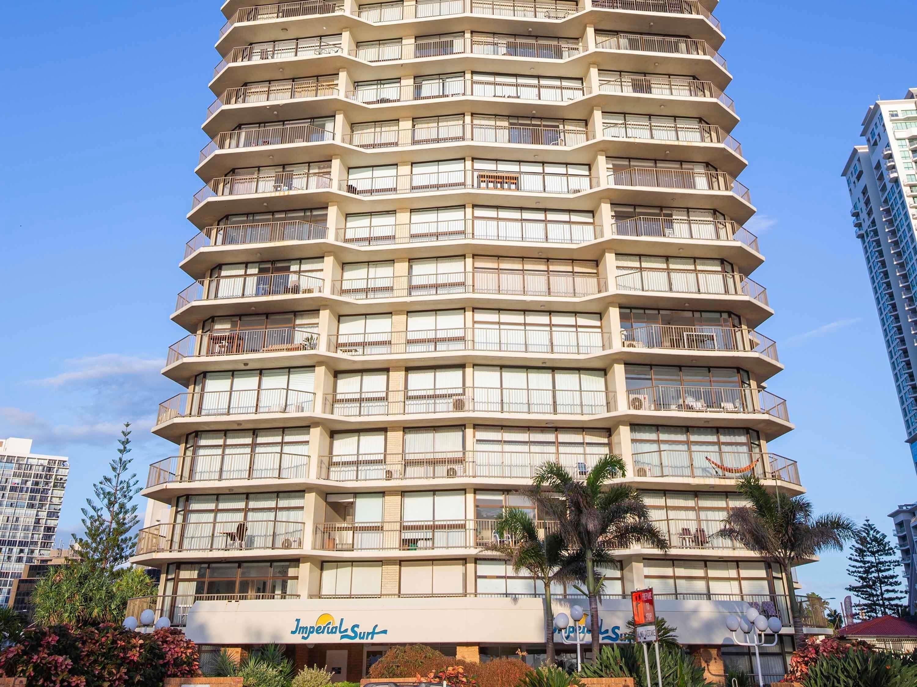 A multi-story hotel with balconies, a sign for Imperial Surf, and a Super 8 sign.