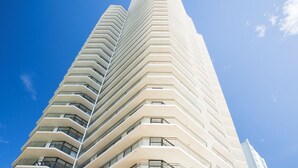 A tall, modern building with a zigzagging facade and balconies. - Breakfree Imperial Surf (Surfers Paradise)