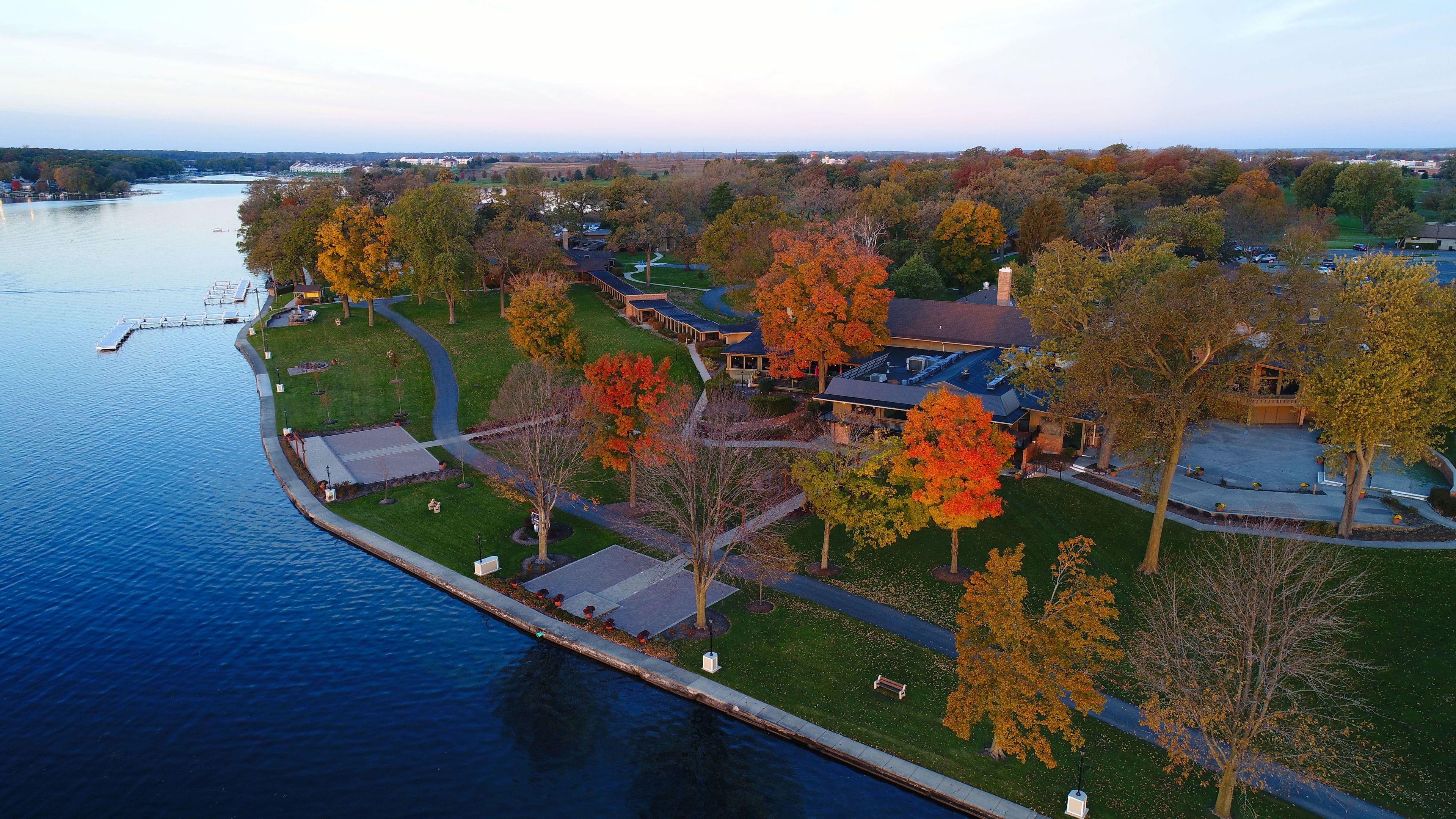A riverside property with a large house, a dock, and a well-maintained lawn.