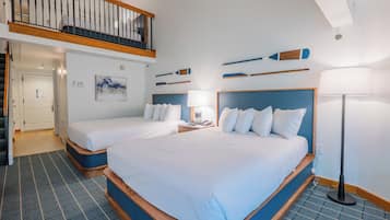 A hotel room with two beds, a balcony, a painting, and a lamp.