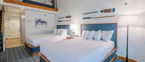 A hotel room with two beds, a balcony, a painting, and a lamp.
