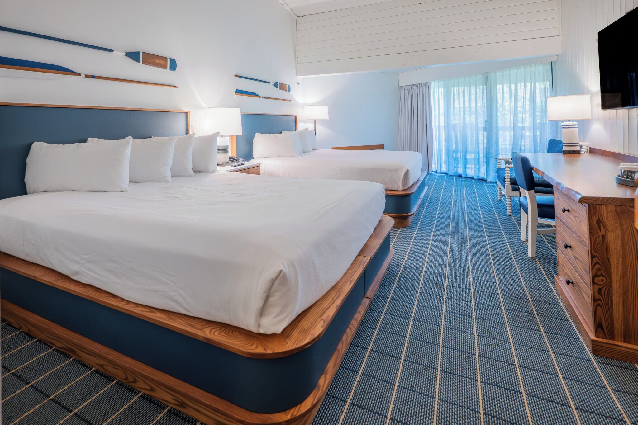 Una habitación de hotel con una cama grande, un escritorio y un televisor.
