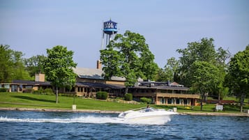 A waterfront property with a boat dock, a water tower, and a building with a lawn and trees.