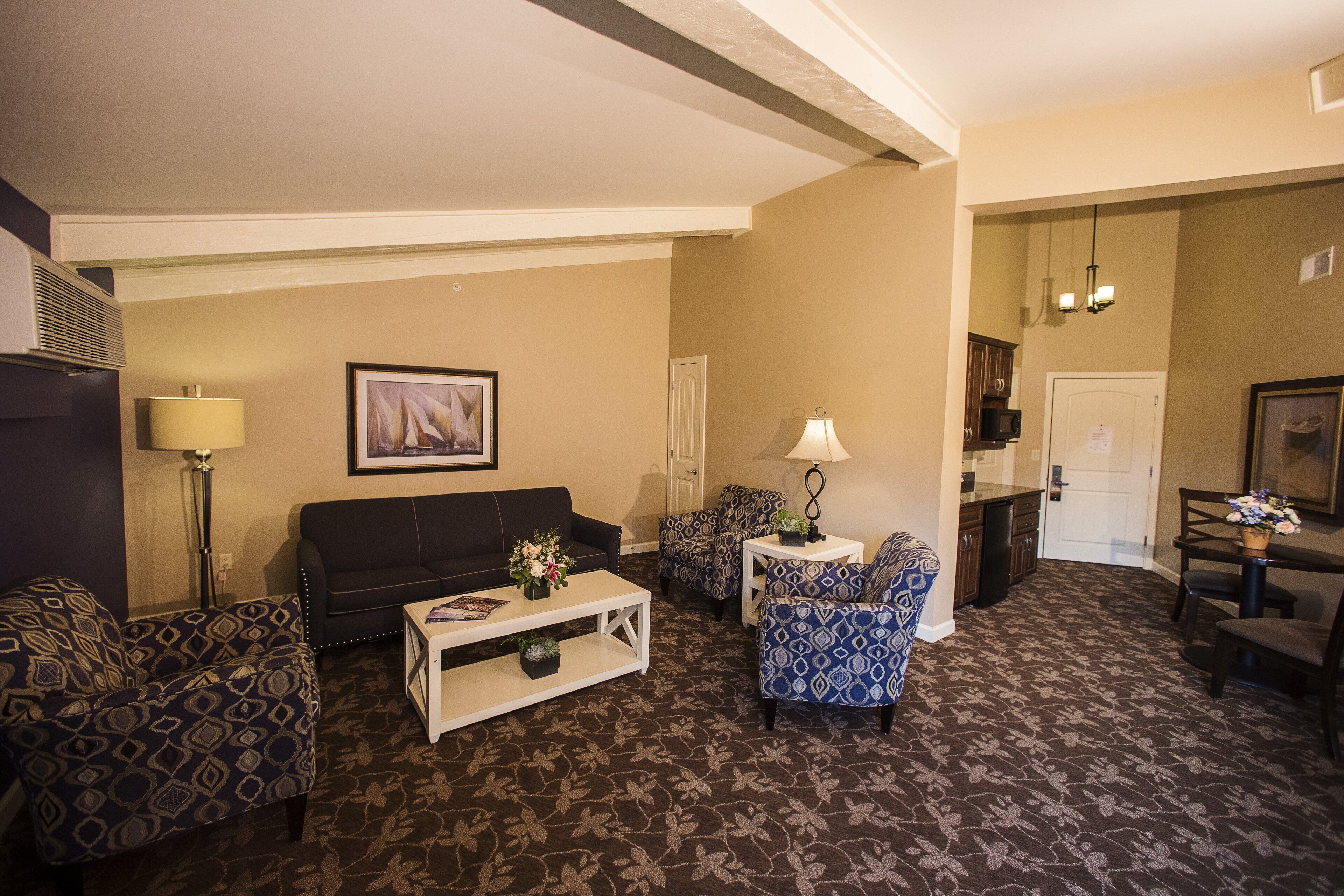A living room with patterned furniture, a coffee table, and a painting on the wall.