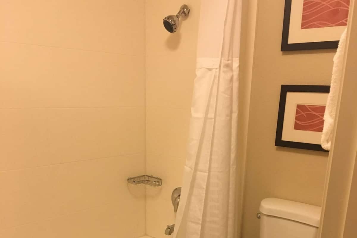 A bathroom with a bathtub, toilet, and a shower curtain.
