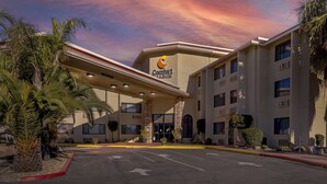 Um Comfort Inn com design moderno, apresentando uma entrada central, vários andares e estacionamento.