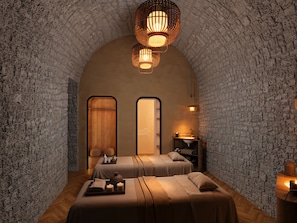 A cozy, stone-walled room with two beds, a wooden bench, and a small table with candles and a vase. - Grand Tonic Hôtel & SPA Paris (Paris)