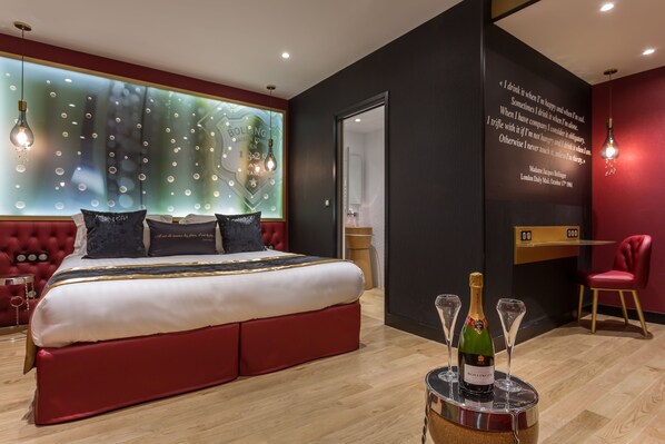 A modern hotel room with a large bed, a red upholstered headboard, and a wall with a quote. - Hotel Les Bulles de Paris (Paris)