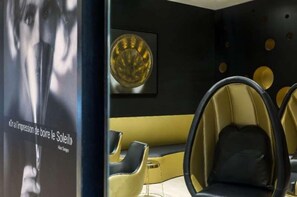 A modern interior with a black and yellow color scheme, featuring a sofa and two chairs with black cushions.