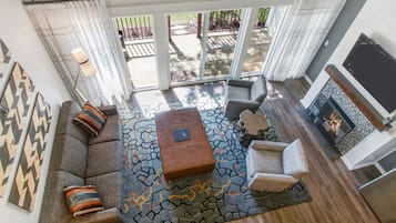 A modern living room with a gray sofa, patterned rug, and a fireplace.