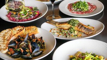A variety of dishes on plates, including seafood and salads.