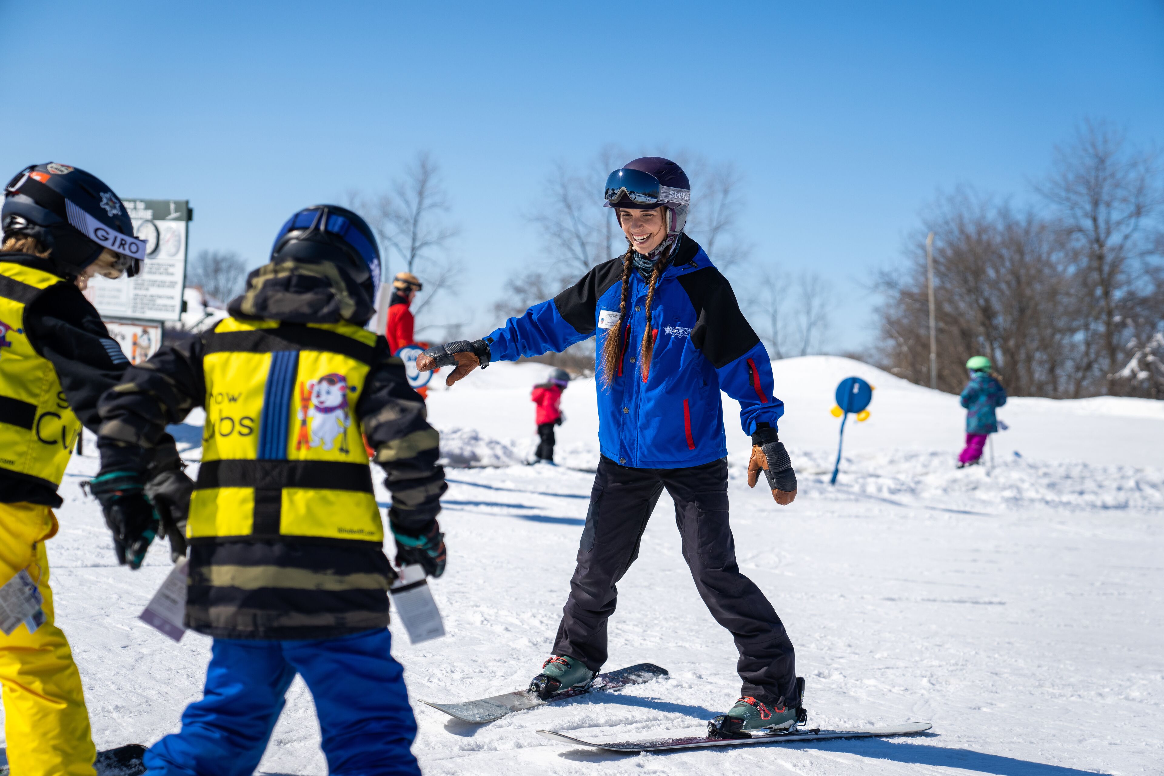A snowy outdoor area with people wearing winter sports gear.