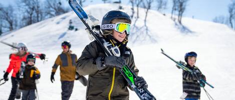 A group of people on a snowy slope, some holding skis.