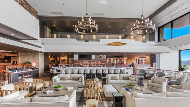Eine geräumige Lobby mit Barbereich, Sitzgelegenheiten und Blick ins Freie.