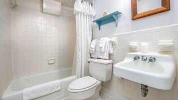 Un baño con bañera, inodoro y lavamanos.
