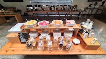 Montaje de un bufé de desayuno con diversos alimentos y salsas.