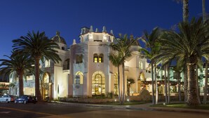 A large, historic building with arched windows and a central tower, surrounded by palm trees. - Santa Barbara Inn (Santa Barbara)