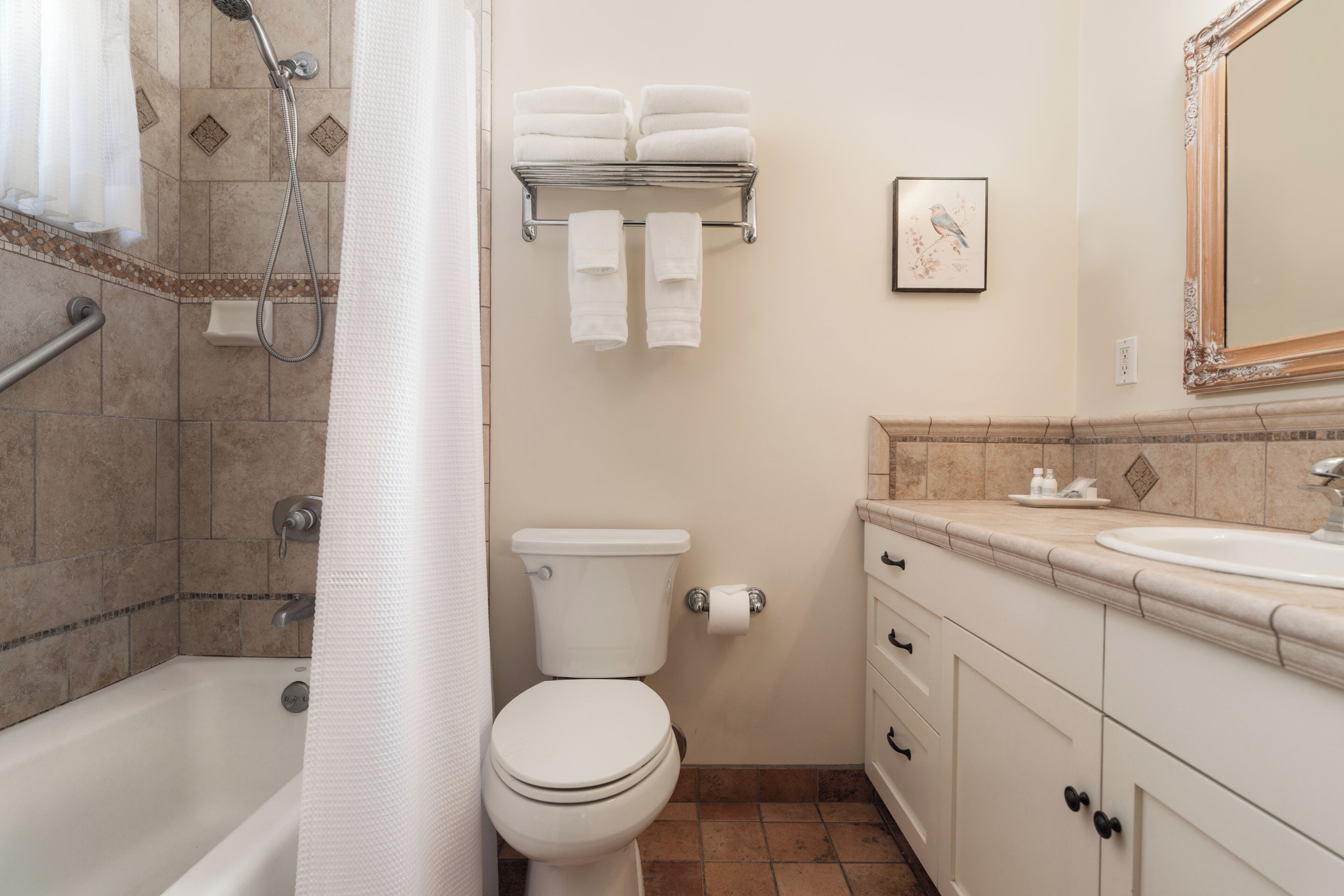 A bathroom with a bathtub, toilet, sink, and towel rack.